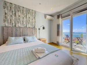 a bedroom with a bed with a view of the ocean at Vibing & Liming Ericeira in Ericeira