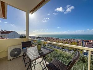 a balcony with a table and chairs and the ocean at Vibing & Liming Ericeira in Ericeira