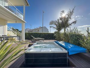 a hot tub sitting on a deck next to a house at Vibing & Liming Ericeira in Ericeira