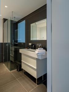ein Badezimmer mit Waschbecken und Spiegel in der Unterkunft Come2Stay Hafencity - Marco Polo Tower 2 in Hamburg