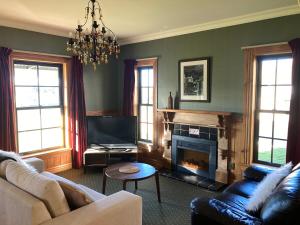 a living room with a couch and a fireplace at Fantail Cottage in Hurunui
