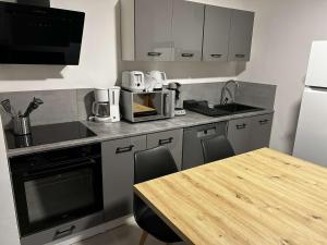 a kitchen with a wooden table and a counter top at appt 4 personnes tout confort 2 in Laveissière +5 photos