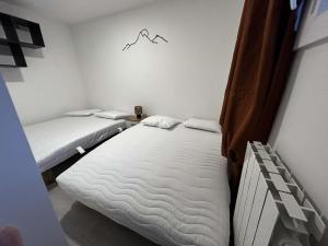 a bedroom with two beds and a mountain sign on the wall at appt 4 personnes tout confort 2 in Laveissière
