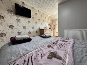 a bedroom with a bed with a tv on the wall at The Kings Head inn in Addlethorpe