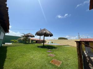 eine Liegewiese mit zwei Sonnenschirmen am Strand in der Unterkunft Casa de praia in São José de Ribamar