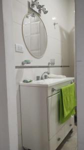 Un baño blanco con lavabo y espejo. en Duplex 79, en Necochea