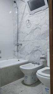 Un baño con inodoro, bañera y lavabo. en Duplex 79, en Necochea