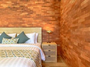 a bedroom with two beds and a brick wall at The Damari Villa Umalas in Canggu