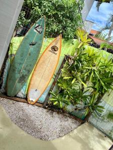 two surfboards are sitting next to some plants at Suíte Colorida em Cabo Frio in Cabo Frio