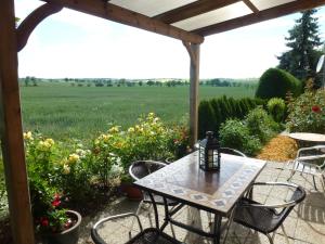 a patio with a table and chairs and a field at Gästehaus Schirner in Niederau