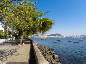 a body of water with trees and boats in it at Casa Colonial 3 Suites na Urca - Rio de Janeiro, Vista Baía Guanabara e Vista Pão de Açucar in Rio de Janeiro