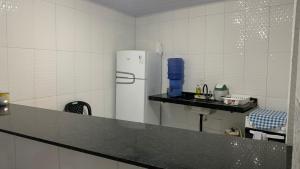 a kitchen with a refrigerator and a counter top at Pousada Valente in Barreirinhas