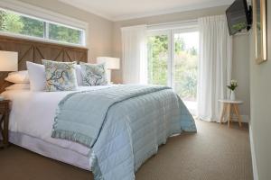 a bedroom with a bed and a large window at Treghan Luxury Lodge in Kerikeri