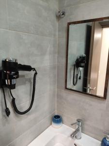 a shower in a bathroom with a sink and a mirror at Neapolis Apartment in Kavála