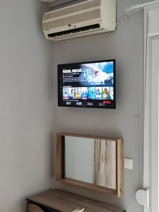 a flat screen tv hanging on a wall at Neapolis Apartment in Kavála +1 photo