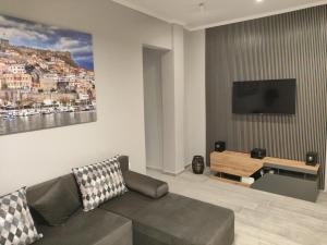 a living room with a couch and a flat screen tv at Neapolis Apartment in Kavála
