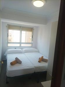 two beds in a small room with a window at El Cabanyal 400m from the Beach in Valencia