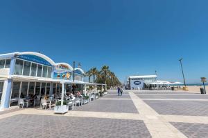 a building with tables and chairs on a street at El Cabanyal 400m from the Beach in Valencia