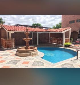 a swimming pool with a fountain in front of a house at hotel brisas del pacifico in Puerto Vallarta