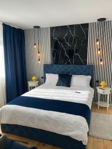 a bedroom with a large bed with a blue headboard at RED HOUSE Sinaia in Sinaia