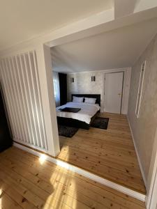 a bedroom with a bed and a wooden floor at RED HOUSE Sinaia in Sinaia