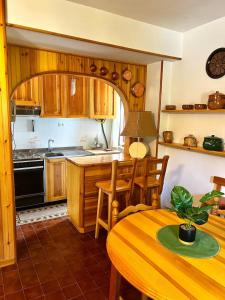 eine Küche mit Holzschränken und einem Holztisch mit einem Tisch in der Unterkunft La Casa di Mosk in Castel di Sangro