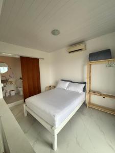 a bedroom with a white bed in a room at Apartamento Rio da Barra in Florianópolis