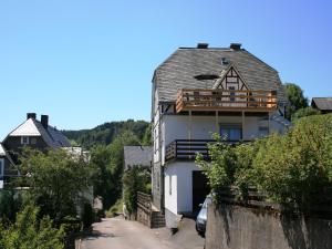a house with a balcony on the side of a street at Ferienhaus in Willingen mit eigenem Garten in Willingen