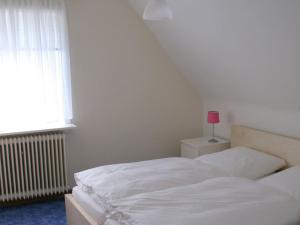 a bedroom with a white bed and a pink lamp at Ferienhaus in Willingen mit eigenem Garten in Willingen +30 photos