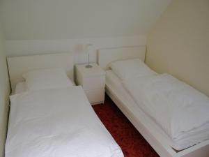 two beds in a small room with white sheets at Ferienhaus in Willingen mit eigenem Garten in Willingen