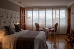 a bedroom with a bed and a table and chairs at Hotel Entre Brumas in Aguadas