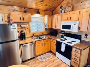 a kitchen with wooden cabinets and stainless steel appliances at Pet Friendly Retreat in Rim Country! With a Spa! in Mogollon Airpark
