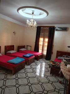 a room with three beds and a chandelier at Villa avec piscine à ORAN in Oran +8 photos