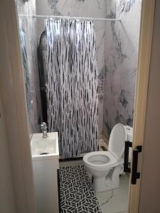 a bathroom with a black and white shower curtain and a toilet at Villa avec piscine à ORAN in Oran