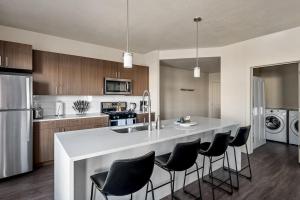 a kitchen with a large white island with black chairs at Gorgeous 2BD 2BA Pool,Gym,Htub near Convention Ctr in Salt Lake City