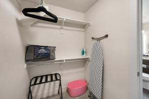 a small bathroom with a pink stool and a shelf at Gorgeous 2BD 2BA Pool,Gym,Htub near Convention Ctr in Salt Lake City