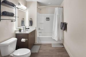 a bathroom with a toilet and a sink and a shower at Gorgeous 2BD 2BA Pool,Gym,Htub near Convention Ctr in Salt Lake City