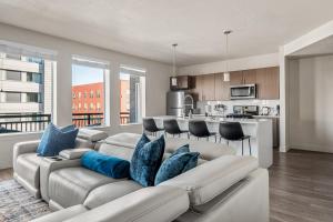 a living room with a couch and a kitchen at Gorgeous 2BD 2BA Pool,Gym,Htub near Convention Ctr in Salt Lake City