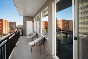 a balcony with two chairs and a view of a city at Gorgeous 2BD 2BA Pool,Gym,Htub near Convention Ctr in Salt Lake City