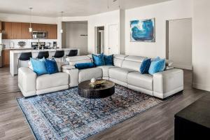 a living room with a white couch and blue pillows at Gorgeous 2BD 2BA Pool,Gym,Htub near Convention Ctr in Salt Lake City
