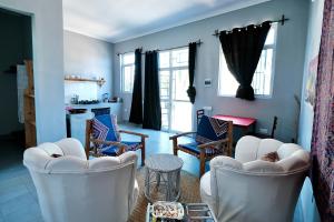 a living room with white chairs and a table at Apartment Kiwengwa in Kiwengwa