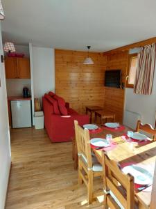 Le MélézetにあるAppartement les orres 1800のテーブルと赤いソファのあるリビングルーム