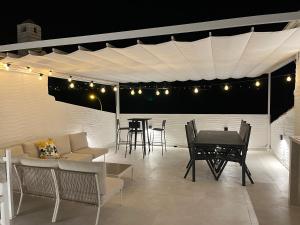 a patio with a table and chairs under awning at Townhouse med takterrass i Costa Hispania in Gran Alacant