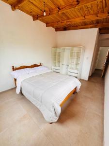 a bedroom with a large white bed with wooden ceilings at propiedades cerca de Güemes y playa grande in Mar del Plata