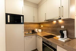 una cucina con mobili bianchi e un piano di lavoro di Sunset Port 402 a Fonyód
