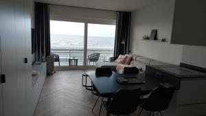 a living room with a couch and a table with chairs at Falcon in Middelkerke