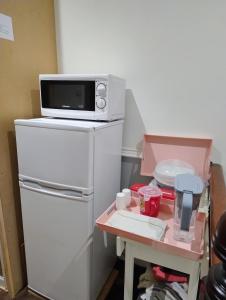 a microwave sitting on top of a refrigerator at Rooms in historic Bishop Auckland in Bishop Auckland