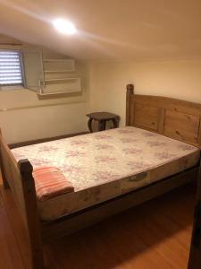 ein Schlafzimmer mit einem großen Bett mit Holzrahmen in der Unterkunft Condomínio Quisisana in Poços de Caldas + 3 Fotos