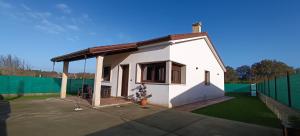 a small white house with a green fence at Casa da Braña in Teo