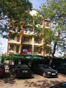 a building with cars parked in front of it at Central Park Family Hotel in Kavarna